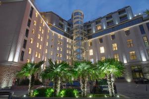 a building with palm trees in front of it at Capital City Center Apart Residence in Plovdiv