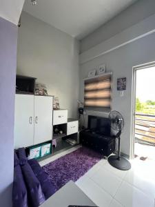 a living room with a purple couch and a fan at JC Unit #8 in Urdaneta