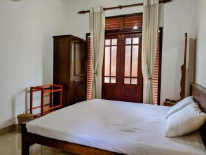 um quarto com uma cama grande e uma janela em Serendip Villa Holiday Home Talalla Sri Lanka em Talalla South