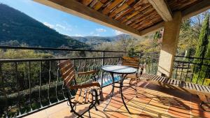 a patio with a table and chairs on a balcony at VILLA CAU B&B - Les Anglores in Claviers