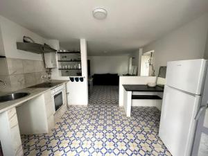 a kitchen with a refrigerator and a table in it at Puskin Suite in Sines