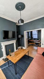 een woonkamer met een tafel en een open haard bij *Hot* Fantastic 3/4 Beds Town House in Anfield Stadium in Liverpool