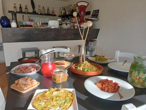stół z wieloma talerzami jedzenia w obiekcie Agriturismo Podere il Fornacino w mieście Santa Luce