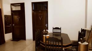 a dining room with a table and two doors at WHITE HOUSE Luxury Rooms - Loved by Travellers, Couples, Corporates in Jalandhar
