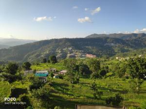 - une vue sur une vallée avec un village sur une colline dans l'établissement MangalMurti Himalyan Hotel, à Almora