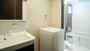 京都的住宿－KAMON INN AIHUKA，白色的浴室设有水槽和卫生间。