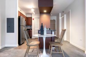 a kitchen with a table and chairs and a refrigerator at Loop 1BR w Pool Gym nr Financial District CHI-281 in Chicago