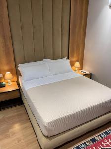 un grande letto in una stanza con due lampade sui tavoli di 313 Villa City Center Hotel a Tirana