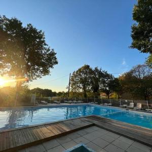 una piscina con el sol brillando sobre ella en n°2 Gîte 4 personnes* au cœur de la nature, en Saint-Aubin-de-Nabirat