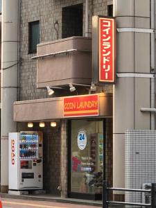 un magasin avec un panneau sur le côté d'un bâtiment dans l'établissement Hatoya Hotel, à Tokyo