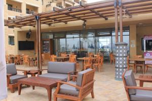 a restaurant with tables and chairs and a television at Samarah Dead Sea Resort Apartment with Sea View FP4 Traveler Award 2024 Winner in Sowayma