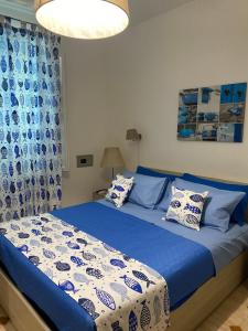 Schlafzimmer mit einem Bett mit blauen und weißen Kissen in der Unterkunft villa martina apartament in Ischia
