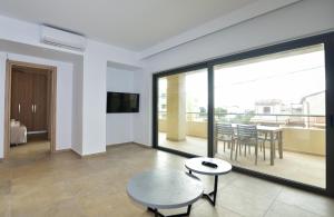 ein Wohnzimmer mit einem Tisch und einem Balkon in der Unterkunft Rosemary Apartments in Palaiochóra