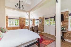 Old Mill Lodge by Huluki Sussex Stays في Hurstpierpoint: غرفة نوم بسرير كبير ومنطقة لتناول الطعام