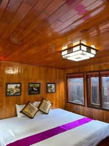 a bed in a room with a wooden ceiling at Cat Ba Boat - Private Boat in Cat Ba