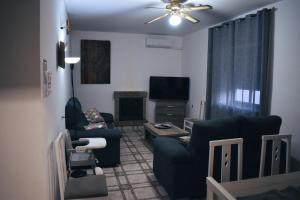 ein Wohnzimmer mit 2 Stühlen und einem TV in der Unterkunft Aljibe Morisco - Casa Rural - in Hornachos