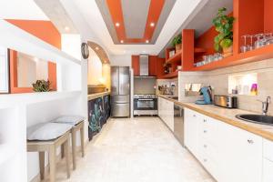 a large kitchen with orange walls and white cabinets at La petite Toscane de Marseille in Marseille