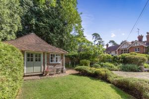 uma casa com um jardim e uma casa em Old Mill Lodge by Huluki Sussex Stays em Hurstpierpoint