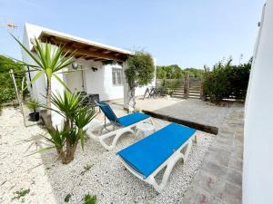 une terrasse avec 2 chaises bleues et blanches et une maison dans l'établissement Ilusiones del Mar, à El Palmar