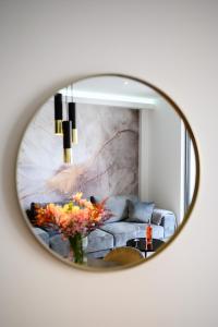 a mirror on a wall with a couch in a living room at Apartman Olimp in Metković