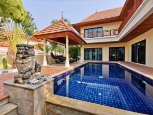 a pool with a statue next to a house at Talay Sawan Pool Villa 27-12 in Bang Sare