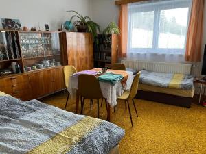 1 dormitorio con mesa, 2 camas y ventana en Přízemí rodinného domu, en Košťálov