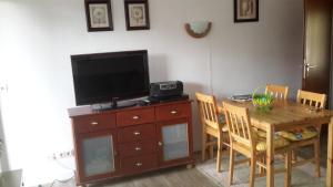 a dining room with a table and a television on a dresser at Niedersfeld Polzweg in Winterberg