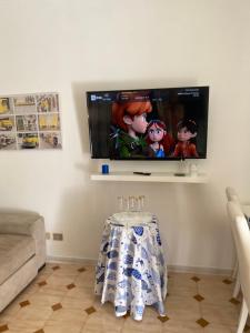 ein Wohnzimmer mit einem Tisch und einem Flachbild-TV in der Unterkunft villa martina apartament in Ischia