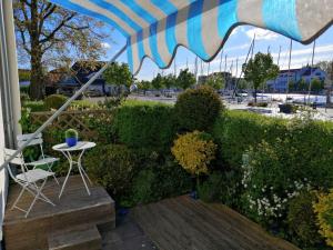 eine Terrasse mit einem Tisch, einem Stuhl und einem Sonnenschirm in der Unterkunft Wiecker Apartment am Ryck in Greifswald