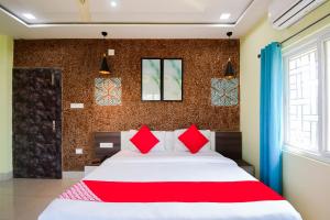 a bedroom with a large bed with red pillows at Flagship Sunshine Stay in Bhubaneshwar