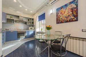 a kitchen with a glass table with chairs and a painting at 2к квартира на Дарвіна, Бессарабка in Kyiv