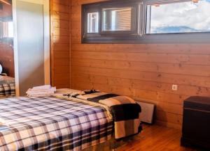 1 dormitorio con 1 cama en una habitación con ventana en Ξυλόσπιτο στη Στενή, en Amfithéa