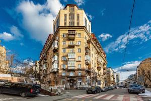 基輔的住宿－2к квартира на Дарвіна, Бессарабка，一条高大的建筑,有汽车停在街上