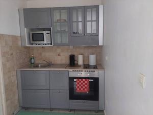 a small kitchen with a stove and a microwave at Fresnay-sur-Sarthe: joli appartement au calme. in Fresnay-sur-Sarthe