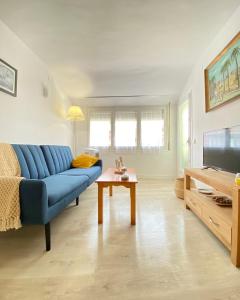 sala de estar con sofá azul y mesa en Apartamento en playa de Altafulla, en Altafulla