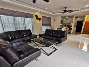 a living room with a leather couch and a table at Talay Sawan Pool Villa 27-12 in Bang Sare