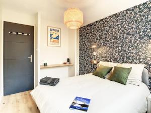 um quarto com uma cama branca e uma parede em preto e branco em Appartement Ancely tout neuf déco aéro - parking gratuit - Proche Blagnac em Toulouse
