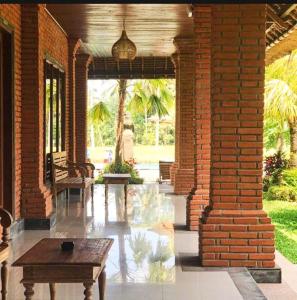 un patio con una mesa y una pared de ladrillo en Intan Villa & Suite Ubud, en Ubud
