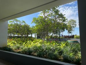 una finestra con vista su un giardino con piante e alberi di SKY LAKE RESIDENCY, PUTRA PERDANA PUCHONG a Puchong