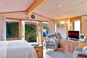 1 dormitorio con 1 cama, escritorio y sillas en The Lodge - Luxury Lodge with Super King Size Bed, Kitchen & Shower Room en Hurstpierpoint