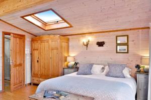 um quarto com uma cama e uma clarabóia em The Lodge - Luxury Lodge with Super King Size Bed, Kitchen & Shower Room em Hurstpierpoint