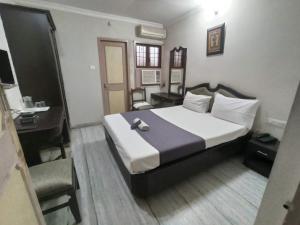 Habitación de hotel con 1 cama, escritorio y 1 dormitorio en Grand tower Chennai, en Chennai