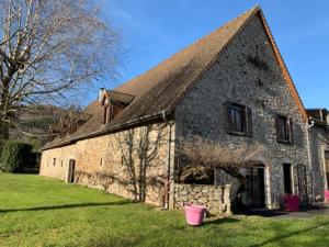 ein altes Steingebäude mit einem rosa Eimer davor in der Unterkunft Logis du lac à Madic in Madic