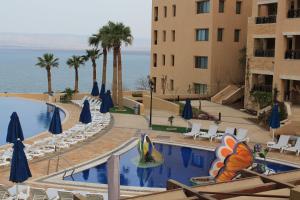 ein Hotel mit einem Pool neben einem Gebäude in der Unterkunft Samarah Dead Sea Resort Apartment with Sea View FP4 Traveler Award 2024 Winner in Sowayma