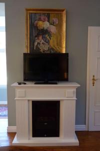 a white fireplace with a tv on top of it at Ferienwohnung Martina & Augusto in Baden-Baden