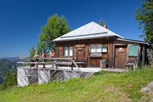 a wooden house with people standing on a bridge at Alpenhotel & Aparthotel Lanz in Hohentauern