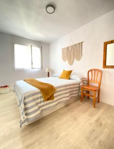 1 dormitorio con cama y silla de madera en Apartamento en playa de Altafulla, en Altafulla