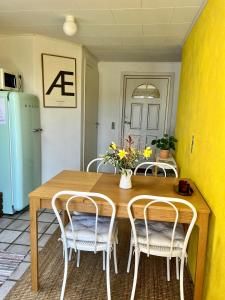 une table à manger et des chaises avec un vase de fleurs dans l'établissement Askes Oase Guest Apartment, à Fjællebroen