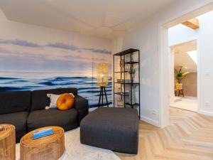 una sala de estar con sofá y una pintura del océano en Villa Brunnenstraße, App 3, en Heringsdorf