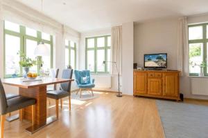 a living room with a table and chairs and a television at Villa Frohsinn App 15 in Bansin